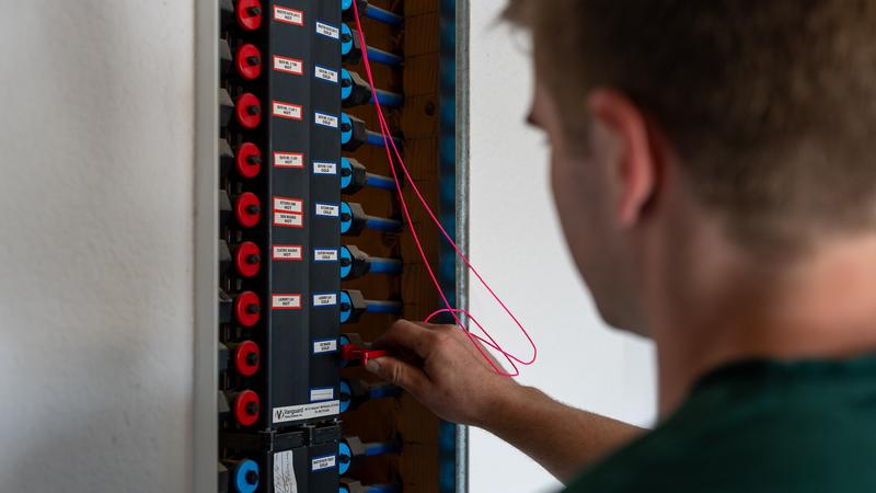 Plumber connecting colour-coded PEX lines at a whole-house repipe manifold