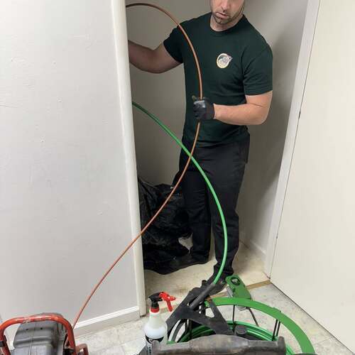 A plumber cleans a drain.